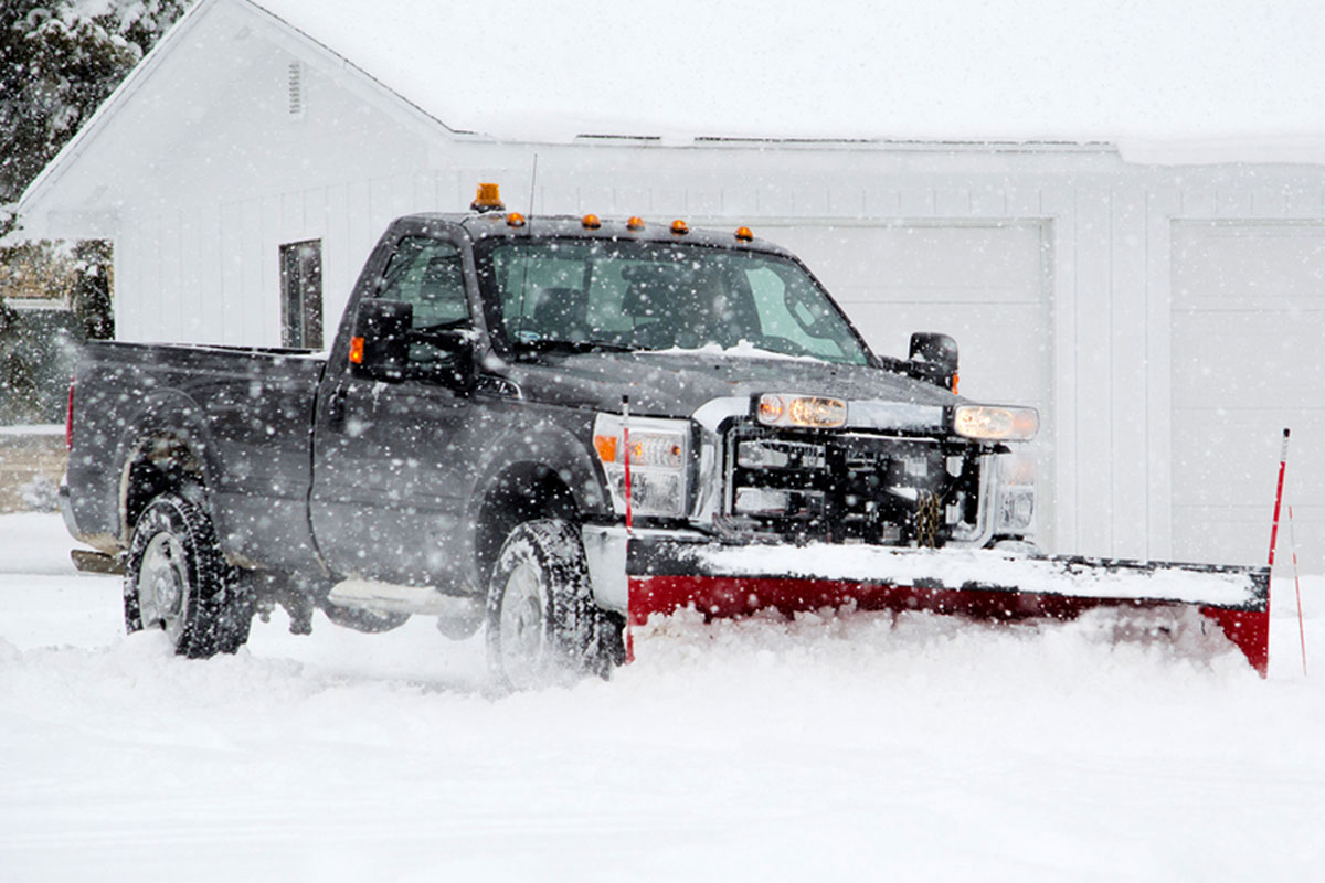 Snow plow clearing a driveway in Algonquin, IL